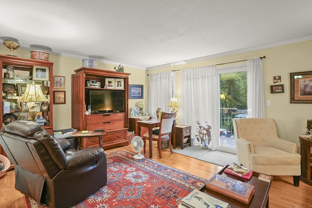 living area with crown molding and light wood-style floors