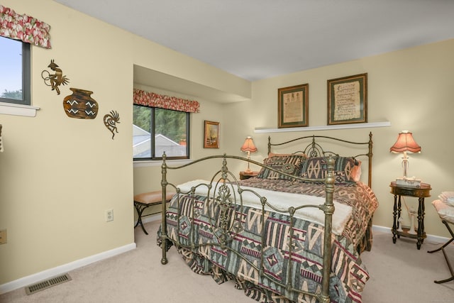 carpeted bedroom featuring visible vents and baseboards