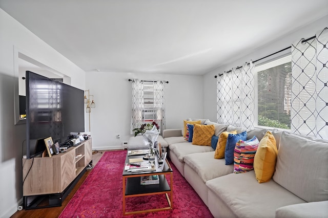 living area with cooling unit, baseboards, and wood finished floors