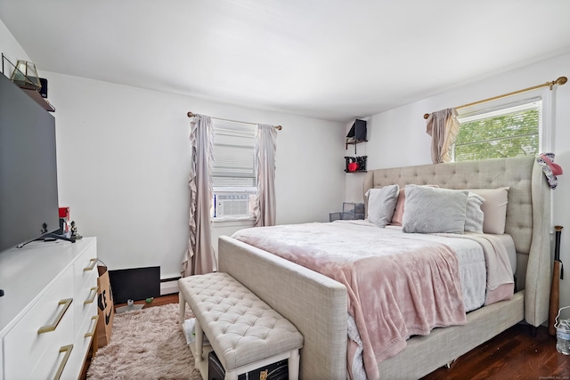 bedroom with dark wood-style flooring and baseboard heating