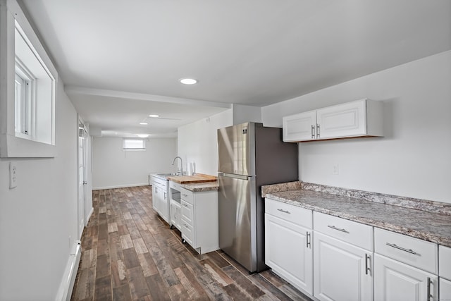 kitchen with recessed lighting, freestanding refrigerator, dark wood-style floors, white cabinetry, and a sink