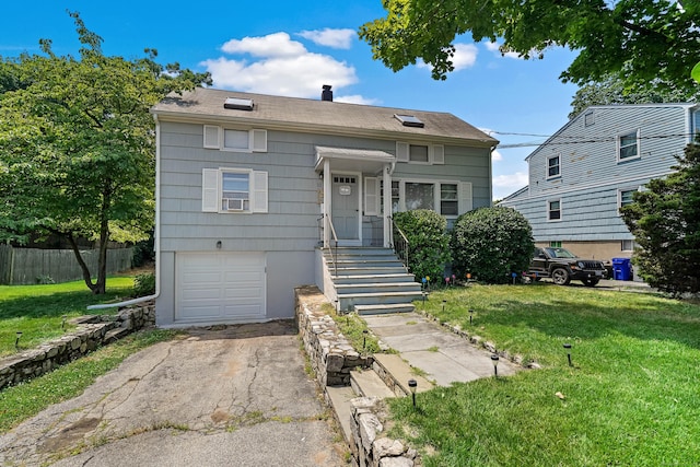 view of front of home with fence, aphalt driveway, a front yard, a chimney, and a garage