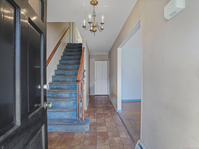 tiled entryway featuring baseboards, stairs, and an inviting chandelier