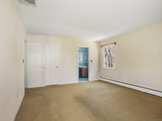 unfurnished bedroom with baseboards, visible vents, ensuite bath, a baseboard heating unit, and carpet flooring