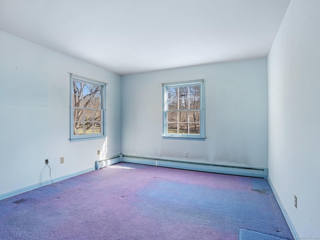 carpeted spare room featuring plenty of natural light, baseboards, and baseboard heating