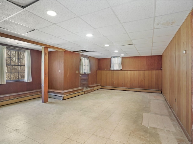 basement with tile patterned floors, wooden walls, recessed lighting, and a baseboard heating unit