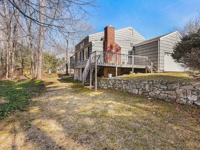 view of property exterior featuring an attached garage, a chimney, stairs, and a deck