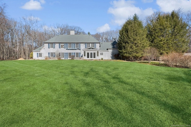 view of front of property featuring a chimney and a front lawn