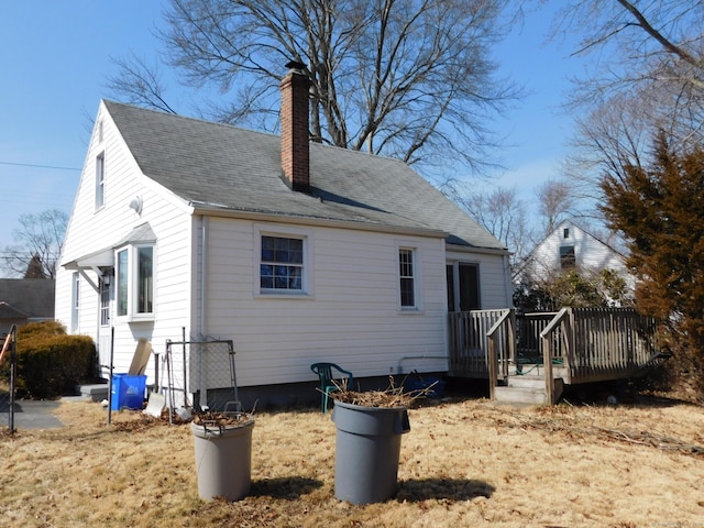 view of property exterior with a wooden deck, a chimney, and roof with shingles