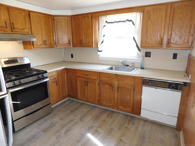 kitchen featuring under cabinet range hood, a sink, gas stove, light wood finished floors, and dishwasher