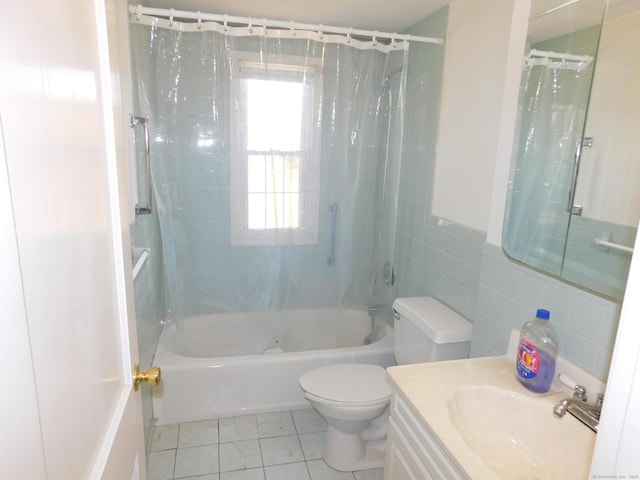 bathroom with tile patterned flooring, tile walls, toilet, shower / bath combo with shower curtain, and vanity