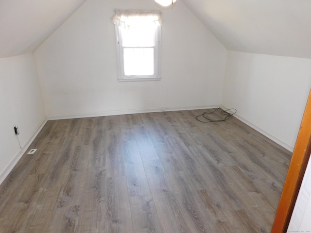 additional living space featuring lofted ceiling, wood finished floors, and baseboards