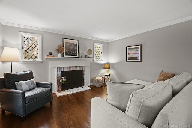 living room with a brick fireplace, wood finished floors, baseboards, and ornamental molding