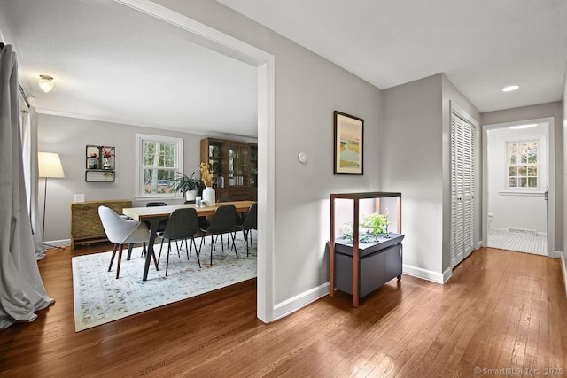 hallway featuring hardwood / wood-style floors and baseboards