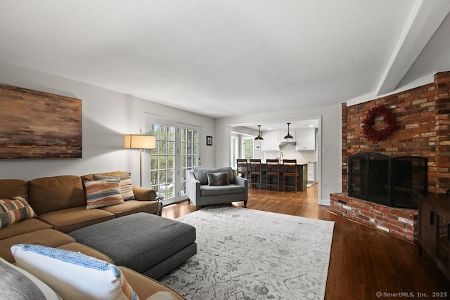 living room with a fireplace, wood finished floors, and a textured ceiling