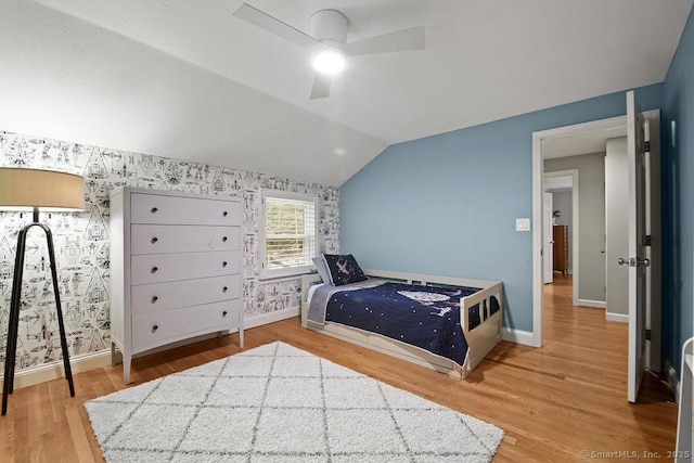 bedroom featuring vaulted ceiling, wood finished floors, baseboards, and ceiling fan