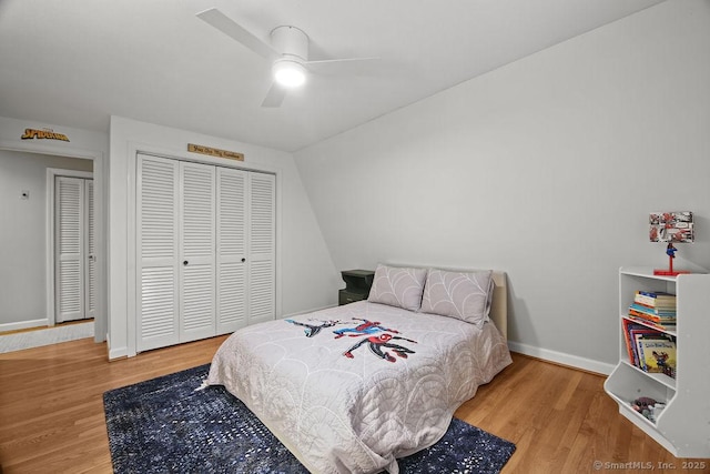 bedroom featuring a closet, baseboards, wood finished floors, and a ceiling fan