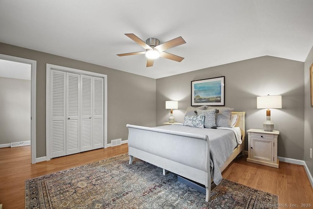 bedroom with light wood-style flooring, visible vents, baseboards, and a closet