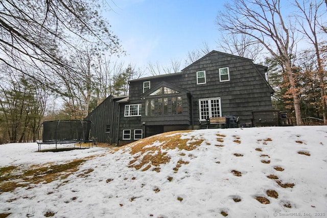 snow covered property with a trampoline