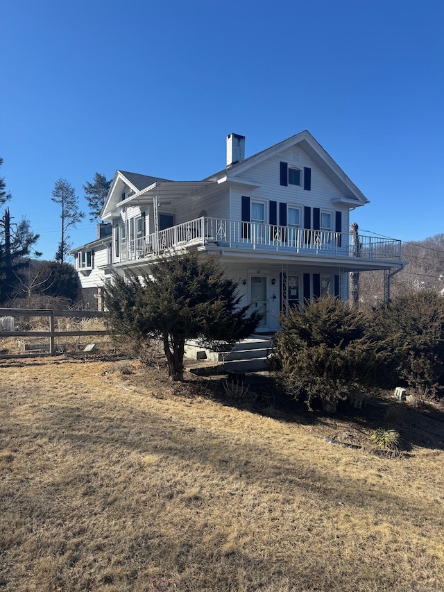 back of house featuring a chimney and fence