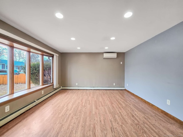 spare room with a baseboard heating unit, wood finished floors, a wall unit AC, recessed lighting, and baseboard heating