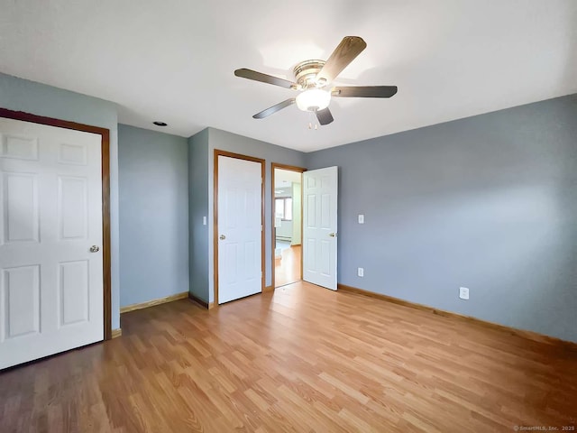 unfurnished bedroom with ceiling fan, light wood-type flooring, and baseboards