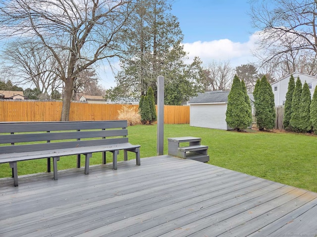 deck with an outbuilding, a yard, a fenced backyard, and a storage unit