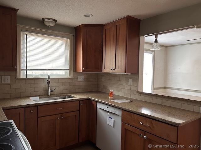 kitchen with a sink, tasteful backsplash, white dishwasher, and a textured ceiling