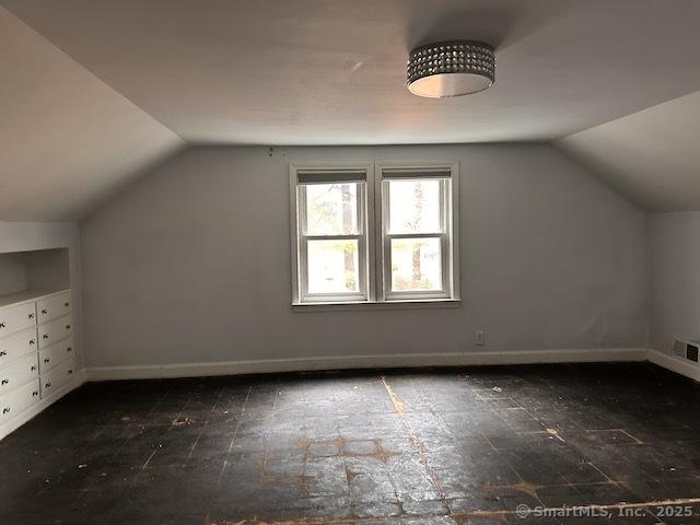 bonus room featuring vaulted ceiling, visible vents, and baseboards