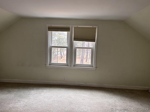 bonus room with baseboards, lofted ceiling, and carpet