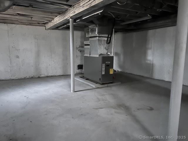 unfinished basement featuring heating unit