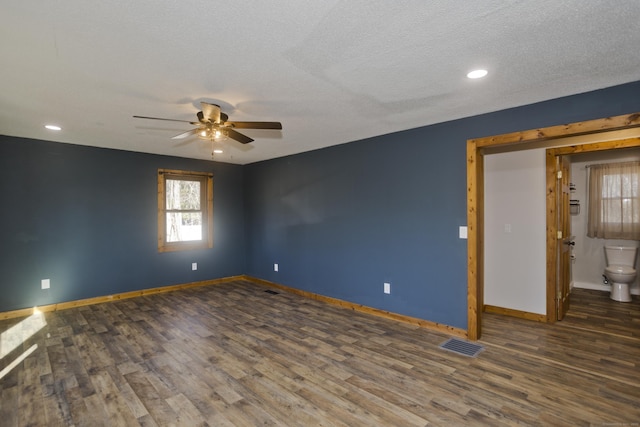 spare room with visible vents, a textured ceiling, baseboards, and wood finished floors