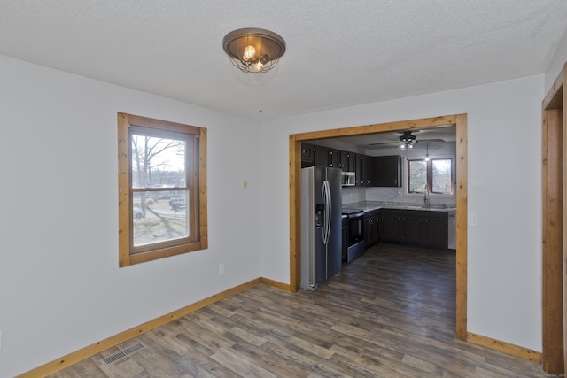 kitchen featuring baseboards, visible vents, dark wood-style flooring, a sink, and appliances with stainless steel finishes