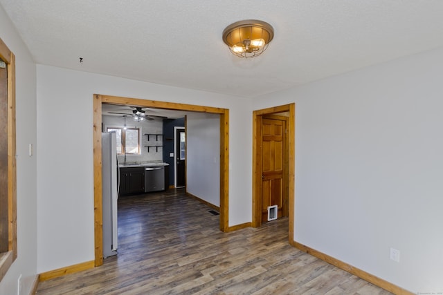 interior space with a sink, dark wood-style floors, visible vents, and baseboards