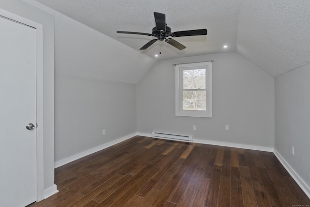 additional living space featuring a baseboard heating unit, a textured ceiling, wood finished floors, baseboards, and lofted ceiling