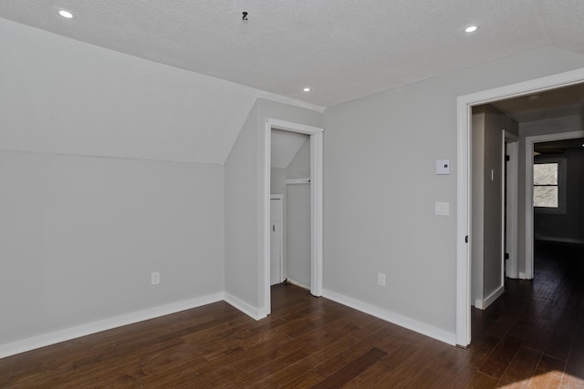 additional living space with lofted ceiling, wood finished floors, and baseboards