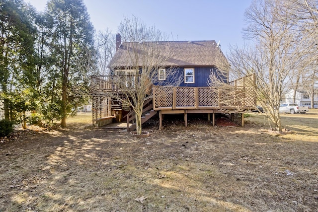 back of property with a wooden deck, a chimney, roof with shingles, and stairs