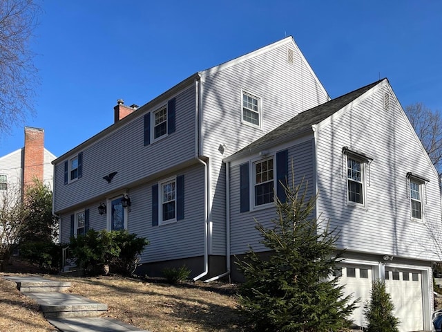 view of property exterior featuring a garage and a chimney