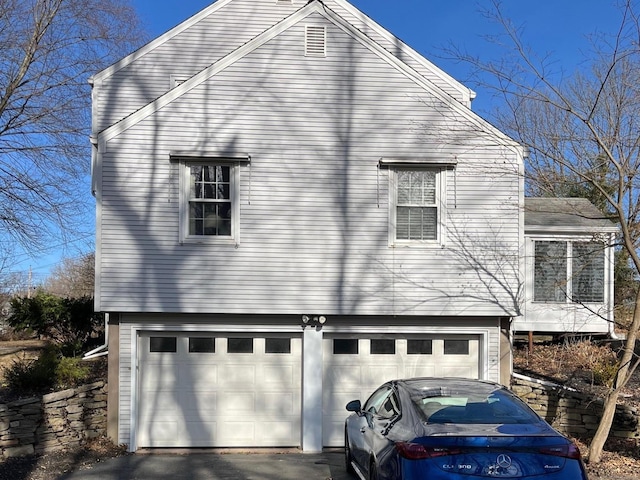 view of home's exterior with an attached garage and driveway