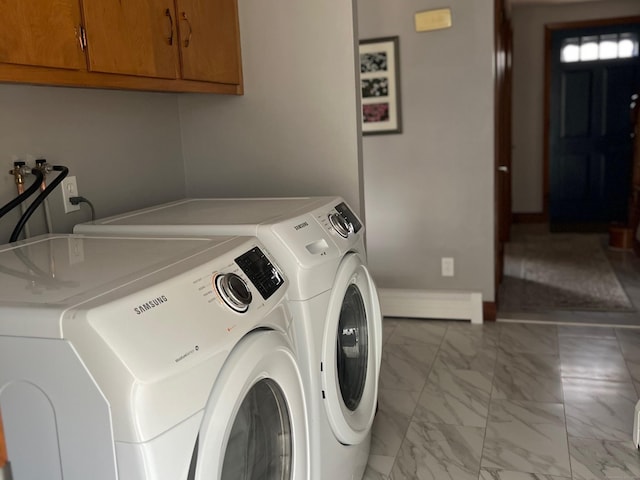 laundry area featuring a baseboard heating unit, baseboards, washer and dryer, cabinet space, and marble finish floor