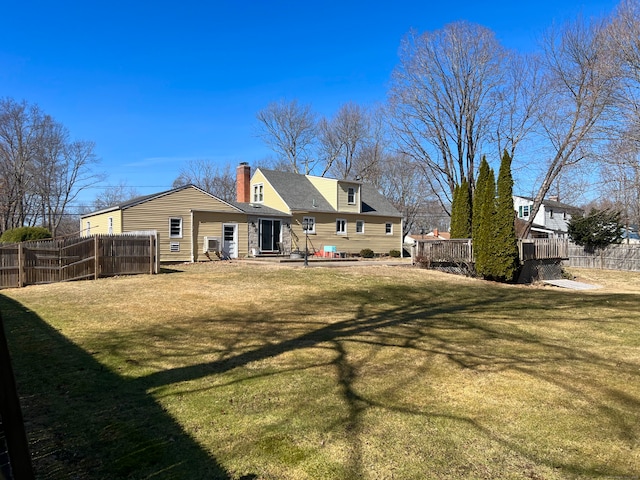 back of house with a yard, a patio area, a chimney, and fence