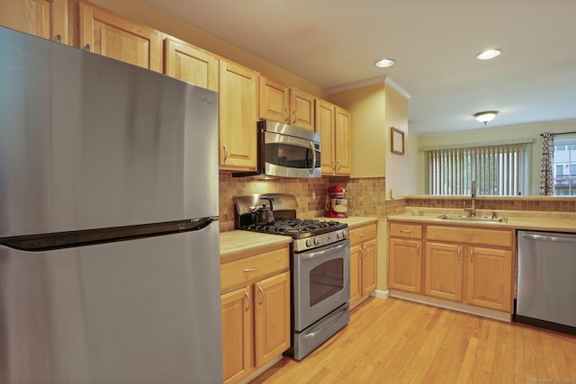 kitchen with light brown cabinets, a sink, backsplash, appliances with stainless steel finishes, and light countertops