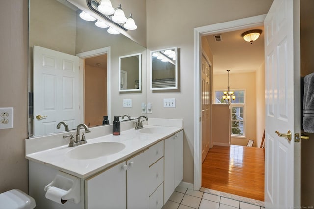 bathroom with tile patterned flooring, a notable chandelier, visible vents, and a sink