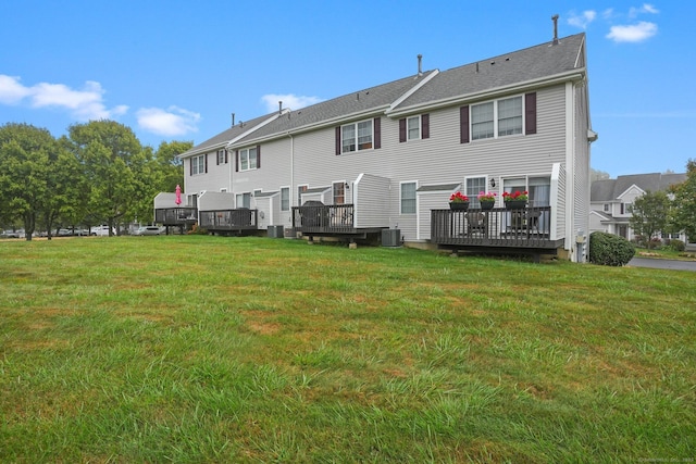 back of house with central air condition unit, a lawn, and a wooden deck