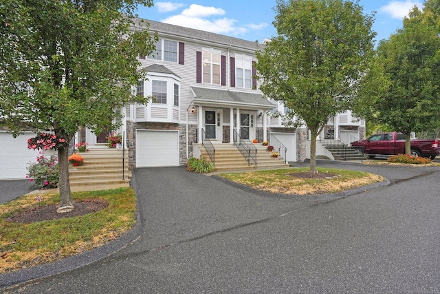 view of front facade with a garage, stone siding, and driveway