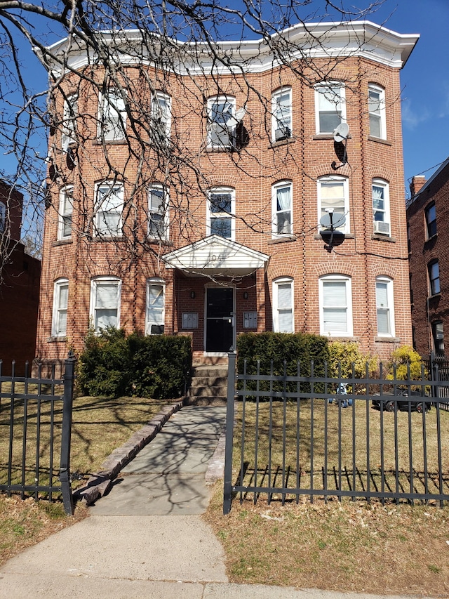 view of front of home featuring a fenced front yard and brick siding