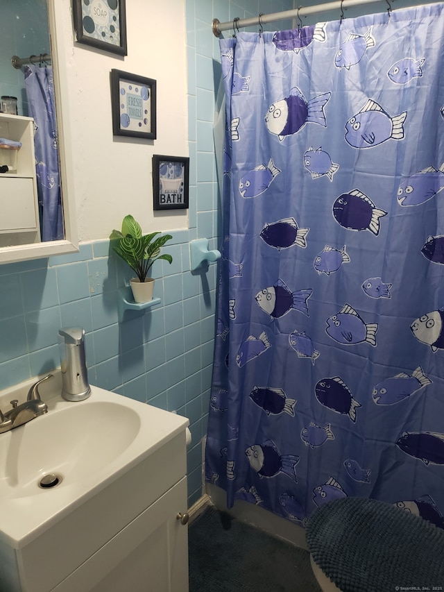 full bathroom featuring vanity and tile walls