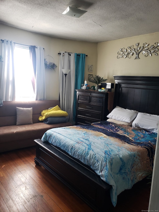 bedroom featuring hardwood / wood-style flooring and a textured ceiling