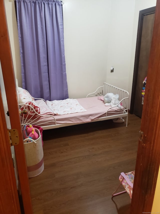 bedroom featuring radiator heating unit and wood finished floors