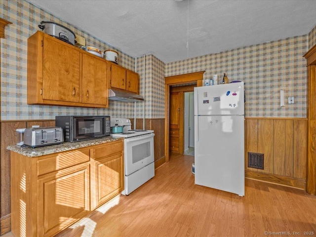 kitchen with white appliances and wallpapered walls